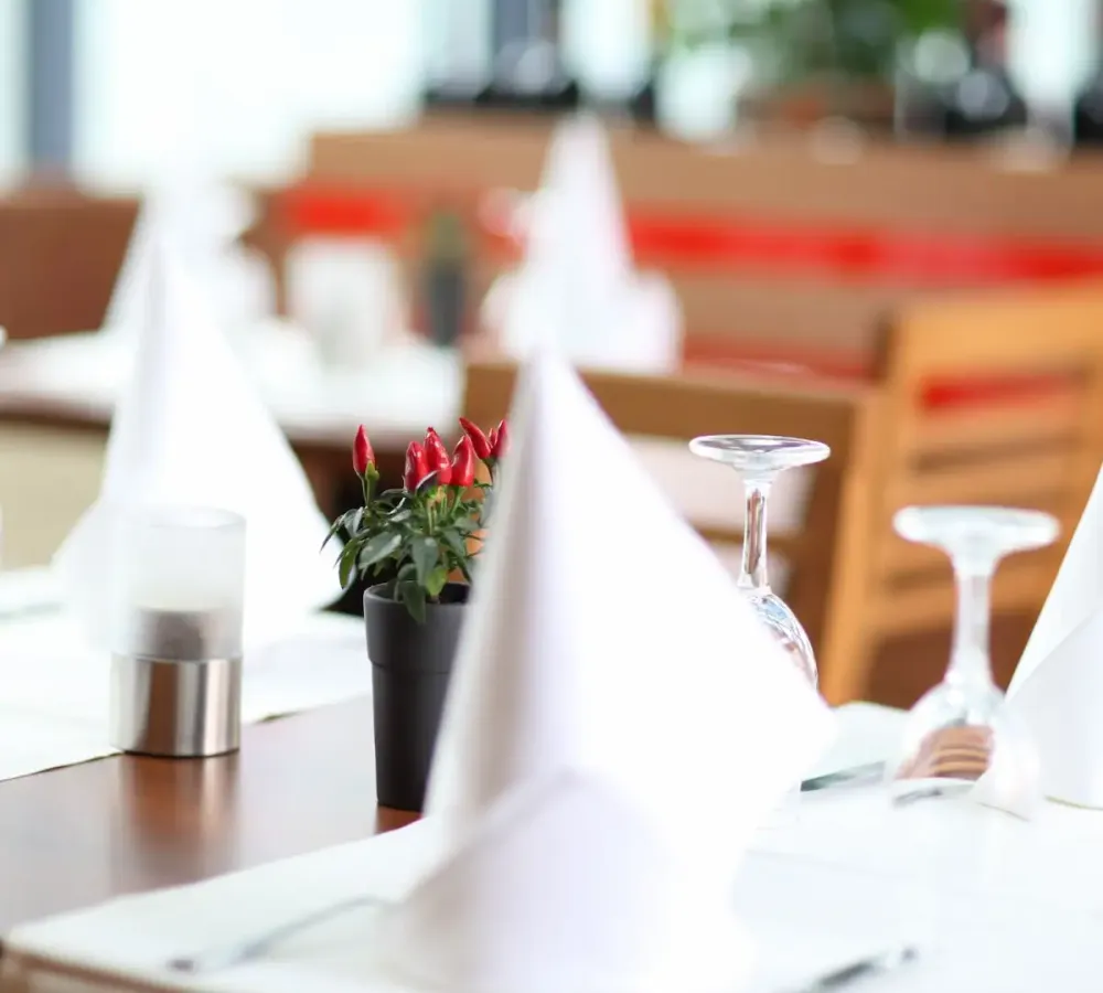 Sorgfältig gedeckter Tisch mit Gläsern und gefalteten Servietten im Primavera